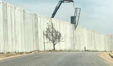 النشرة: ورشة فنية إسرائيلية تركز قواعد حديدية على الجدار الاسمنتي العازل