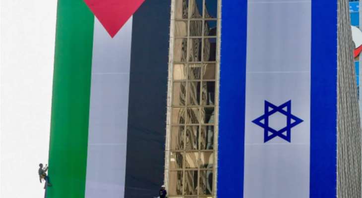 إزالة علم فلسطيني علق إلى جانب علم إسرائيل على مبنى وسط إسرائيل