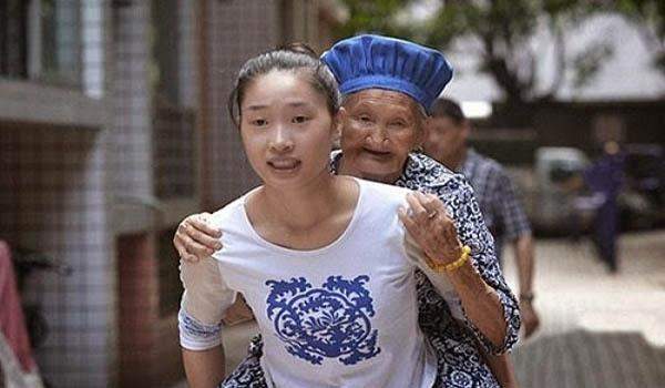  فتاة صينية ترعى جدتها بحملها على ظهرها يومياً لرد الجميل