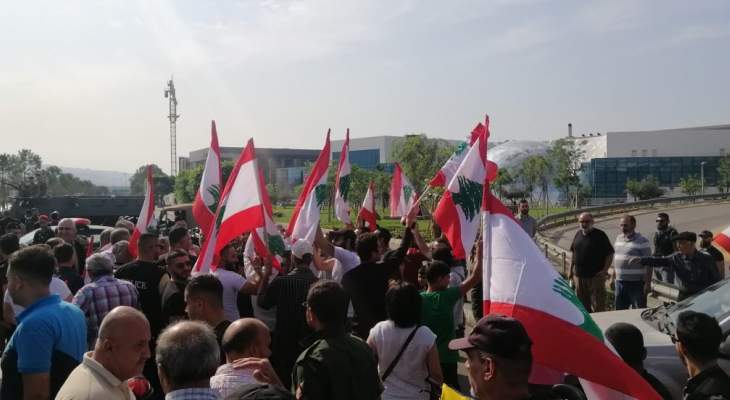 محتجون ينظمون مسيرة على طريق المطار حاملين الاعلام اللبنانية