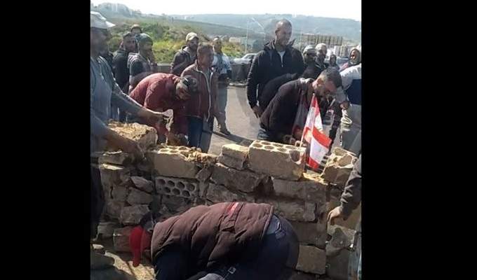 محتجون يبنون جداراً على أوتوستراد البالما في طرابلس